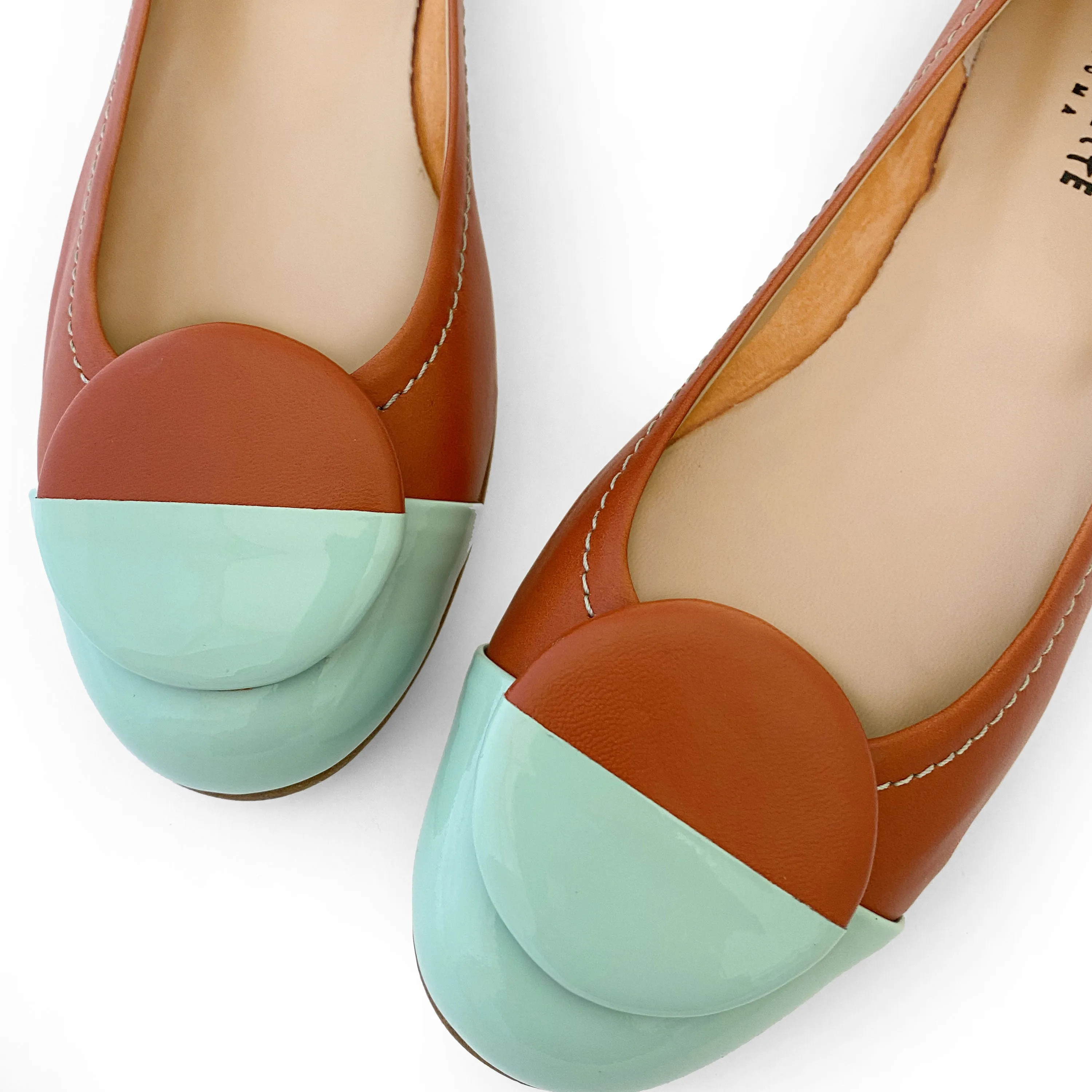 Tan leather ballet flats with green patent leather toe and stud